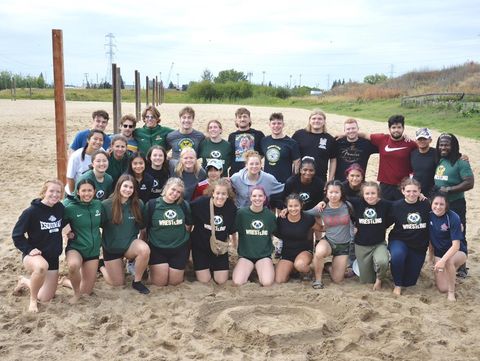 A picture provided by Apphia Wooden showcases the University of Alberta's men's and women's wrestling teams. Coach Owen Dawkins stands on the far right, with Ansh third from the right in the same row, right next to Gavin Cochrane.